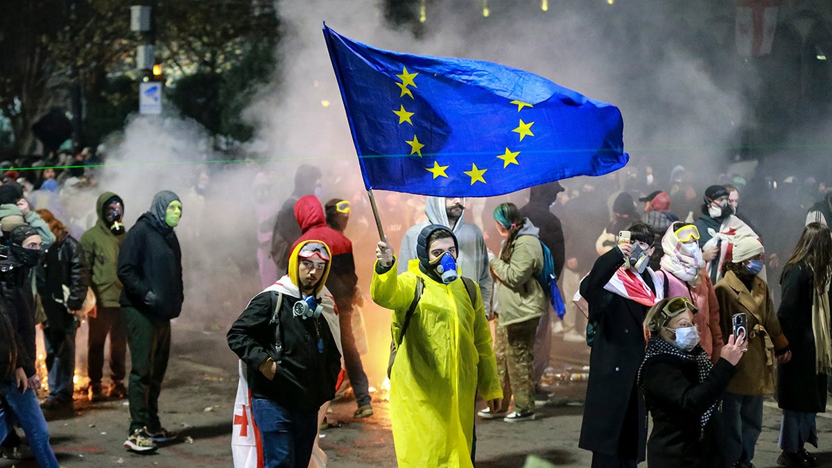 A protester waves a European Union flag during a rally outside the Parliament to protest the government's decision to suspend negotiations on joining the European Union for four years in Tbilisi, Georgia, early Saturday, Nov. 30, 2024.