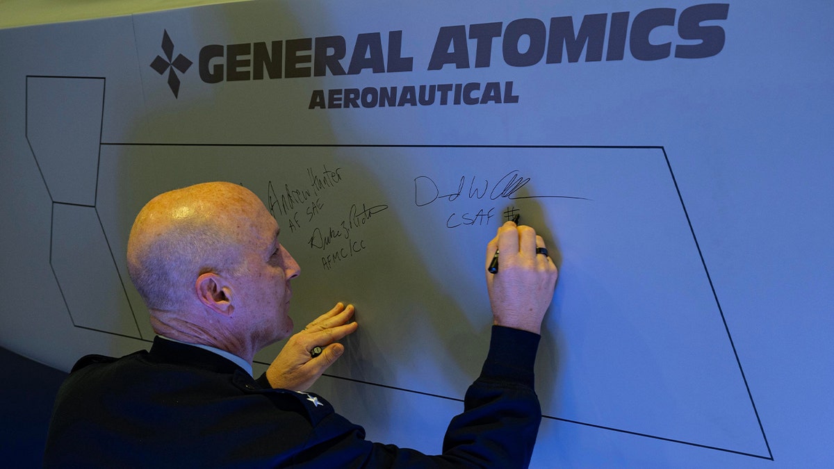 USAF general signs fighter jet