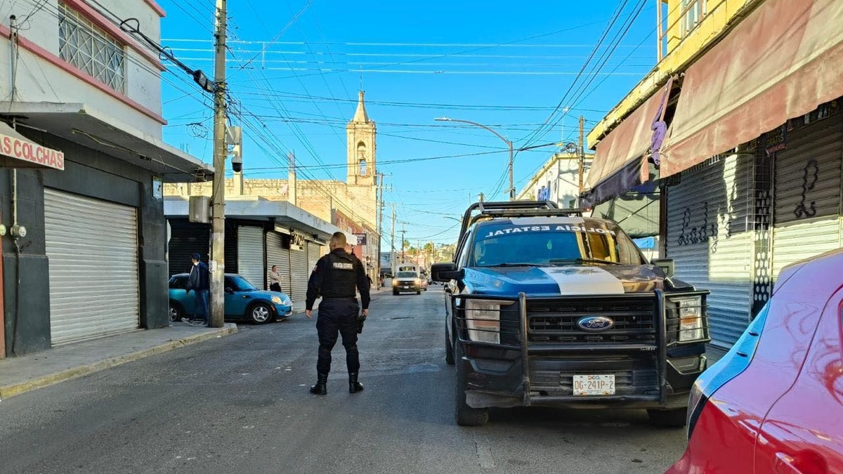 A Durango officer looks out onto a street in the city's historic downtown area