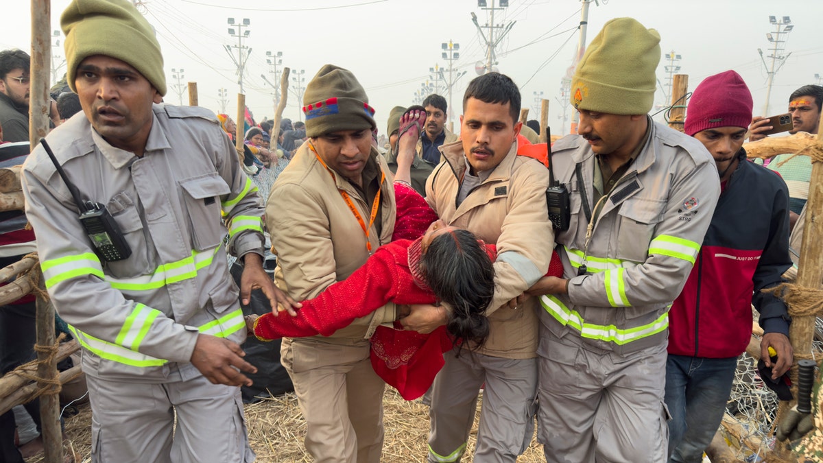 Five security officers carry an injured woman.