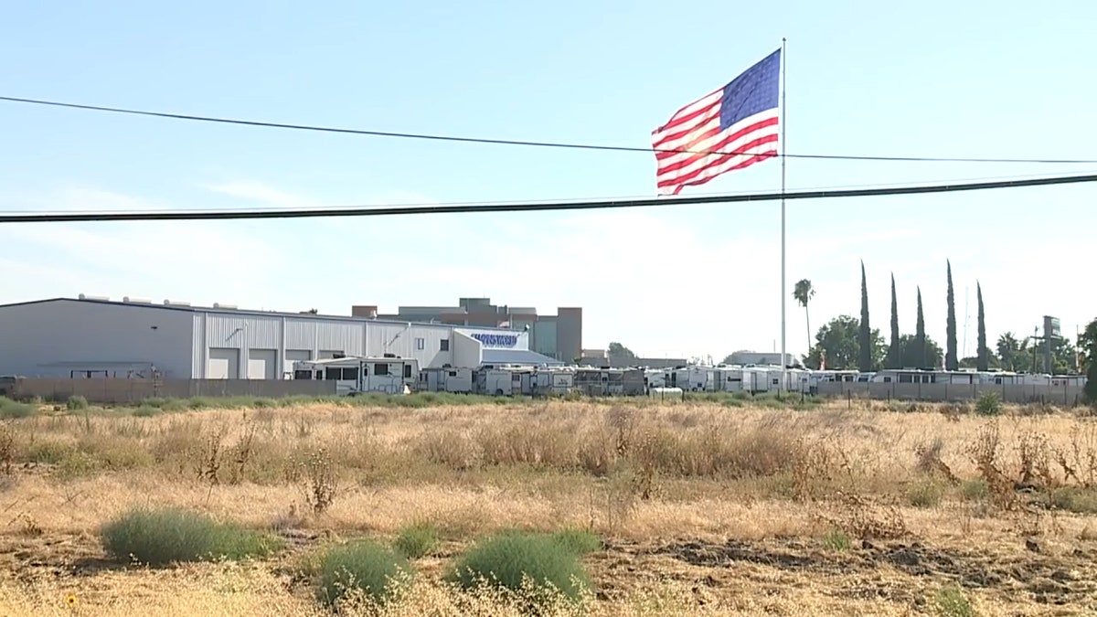 A giant U.S. flag flies atop a 130-foot-tall flag pole outside RV retailer Camping World's French Camp, California.