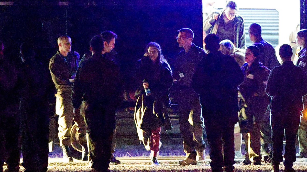 People walk towards Israeli military helicopters as Romi Gonen, Doron Steinbrecher and Emily Damari, three female hostages who have been held in Gaza since the deadly October 7 2023 attack, return to Israel