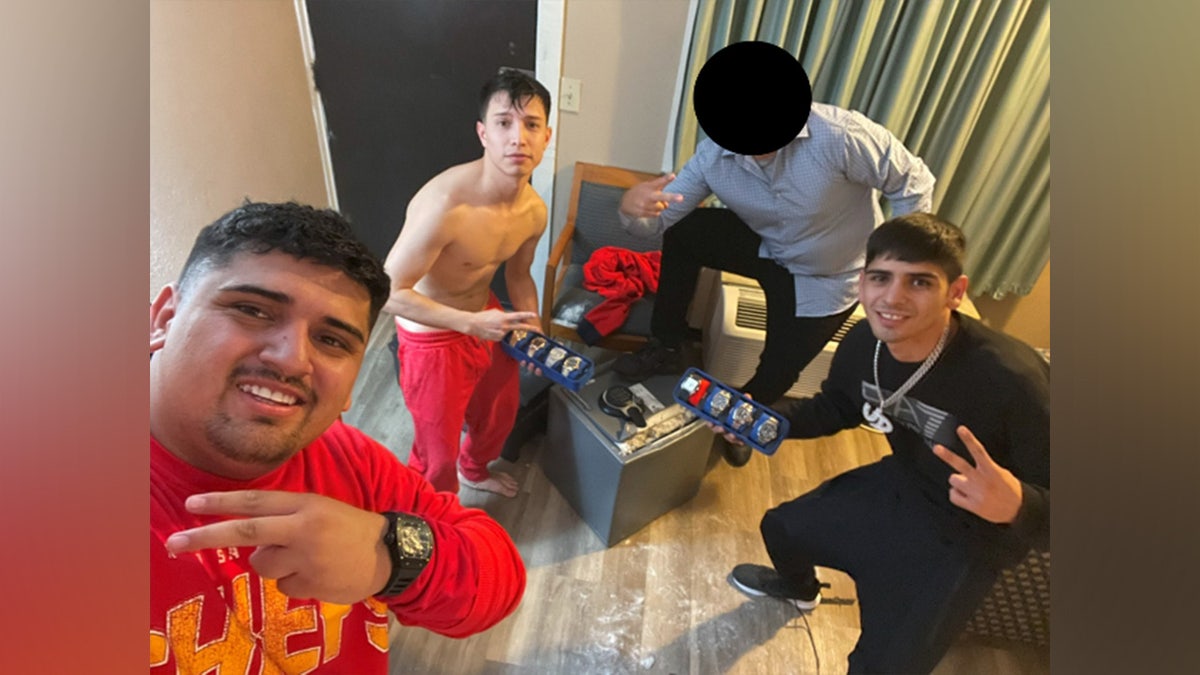 Suspects posing with stolen goods