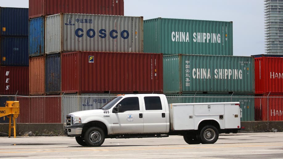 A truck driving past shipping containers