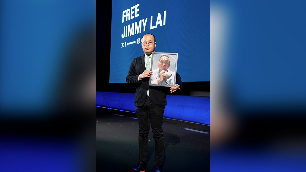 Sebastien Lai holds an image of his father, Apple Daily founder Jimmy Lai