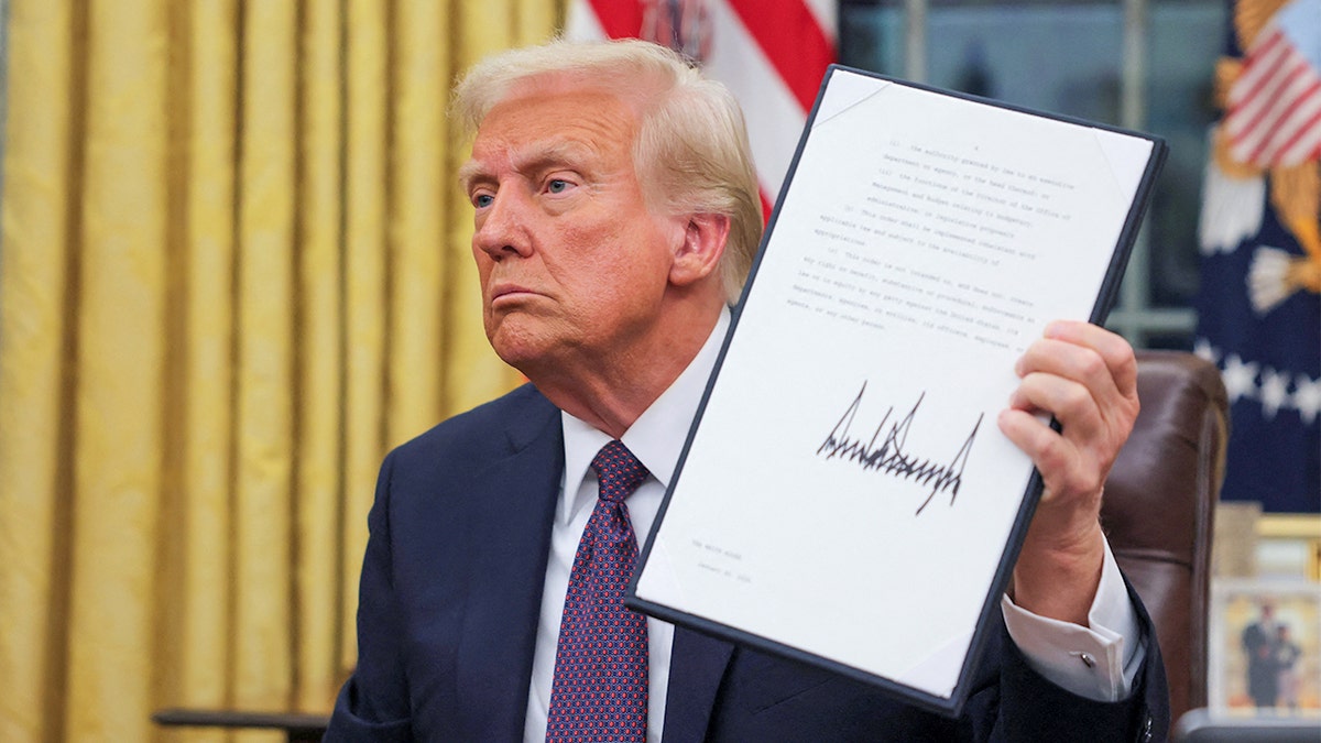 closeup shot, Trump holding up executive order