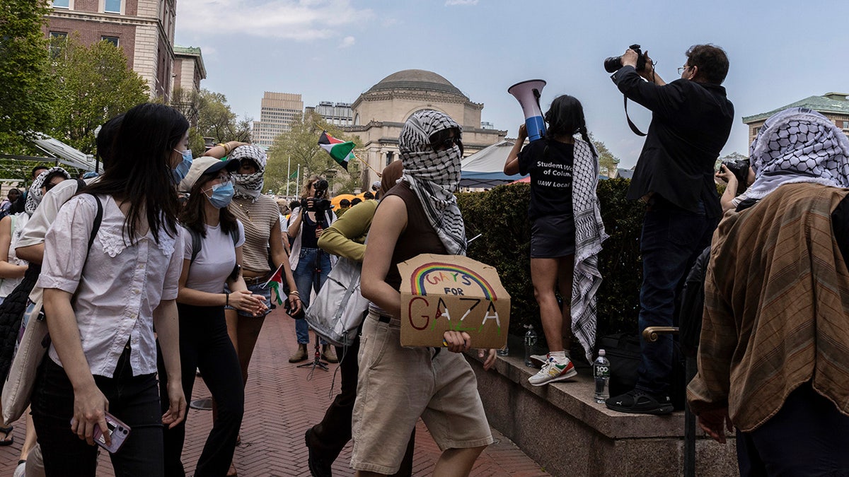 Student protesters march around their encampment on the Columbia University campus