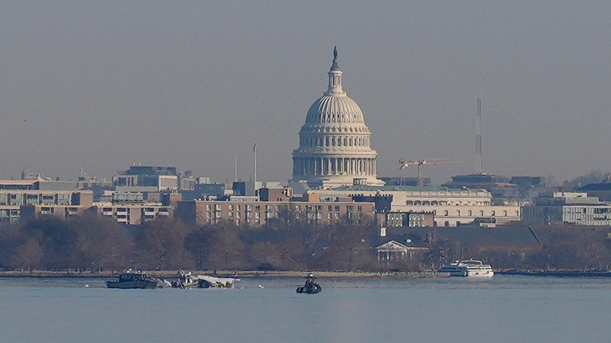 Search and rescue efforts are seen around a wreckage site in the Potomac Rive