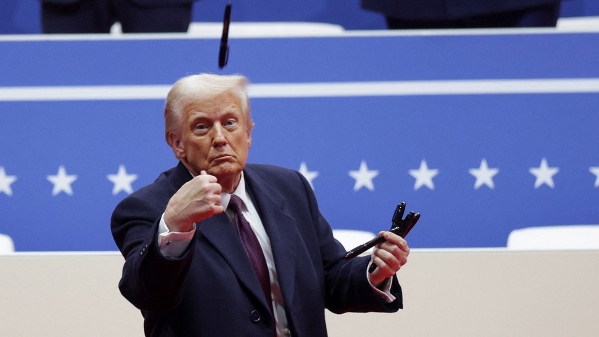 Donald Trump throws a pen during a rally on the inauguration day