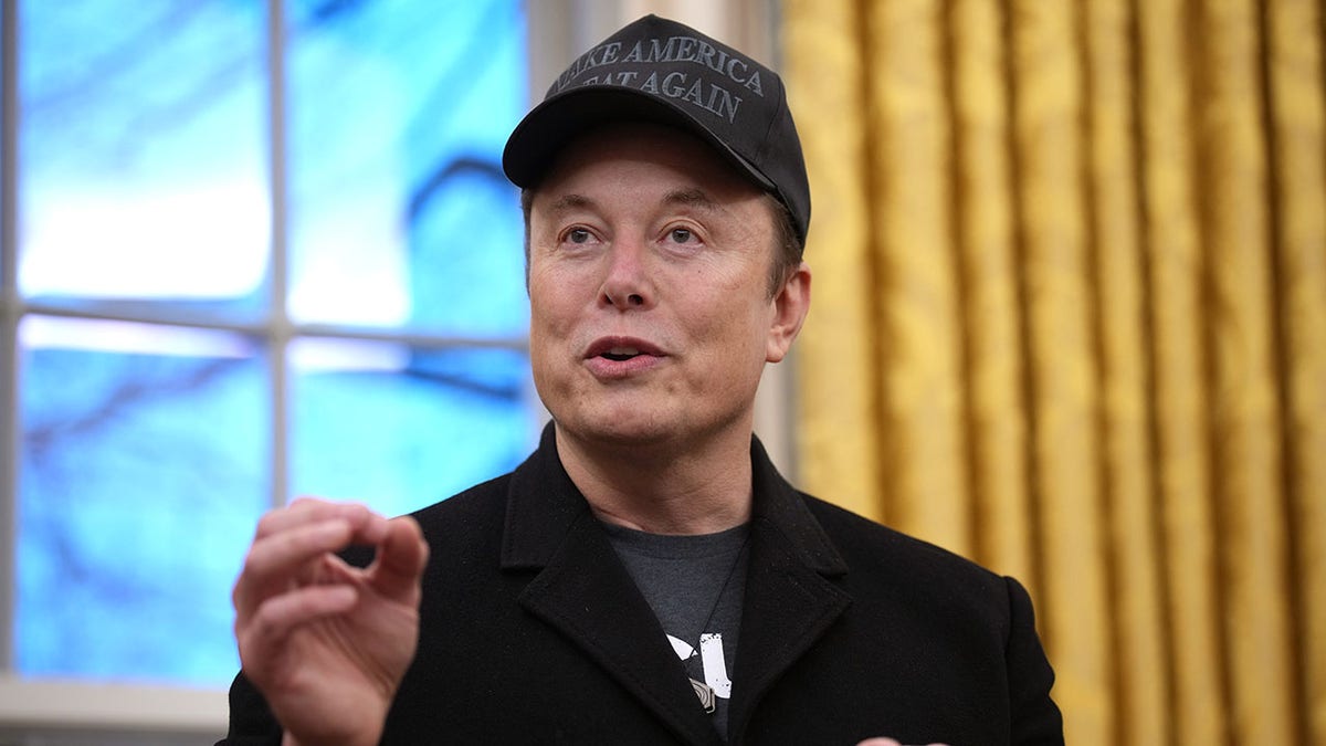 Musk in black MAGA hat in Oval Office