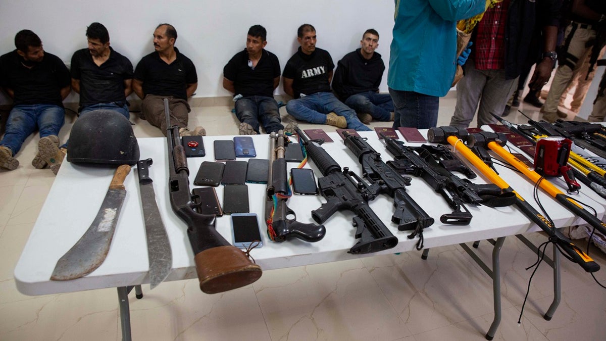 Suspects in the assassination of Haitian President Jovenel Moise are shown to the media, along with the weapons and equipment they allegedly used in the attack, in Port-au-Prince, Haiti, on July 8, 2021. (AP Photo/Joseph Odelyn)