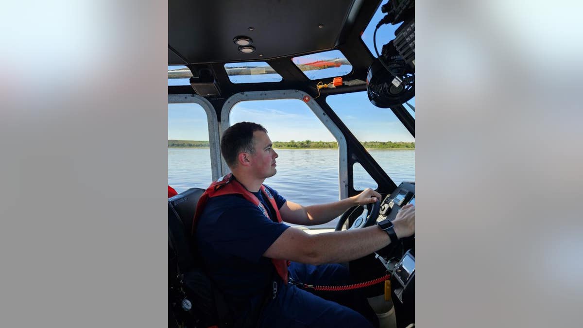 Coast Guard member piloting rescue boat