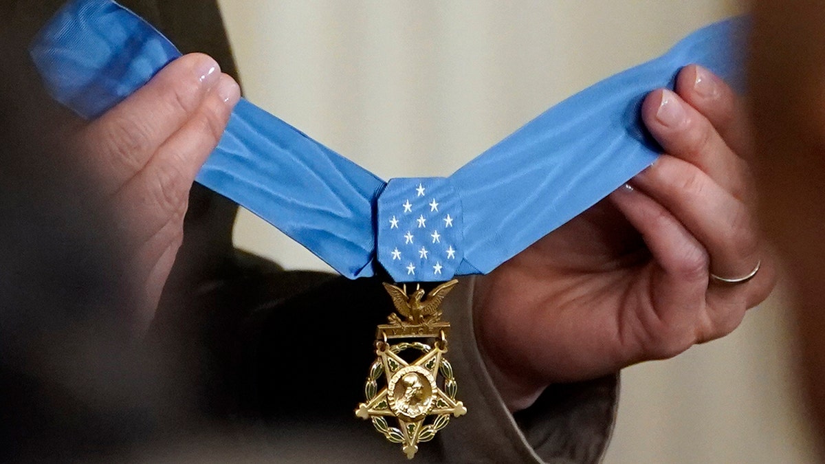 The Medal of Honor being held up by hands