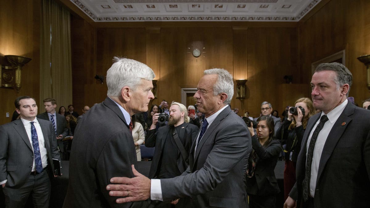 Robert F. Kennedy, Jr., center, President Donald Trump's nominee to serve as secretary of Health and Human Services, talks with Committee Chairman Sen. Bill Cassidy, R-La., left, following his testimony during a Senate Committee on Health, Education, Labor and Pensions hearing for his pending confirmation on Capitol Hill on Thursday, Jan. 30, 2025 in Washington, D.C.