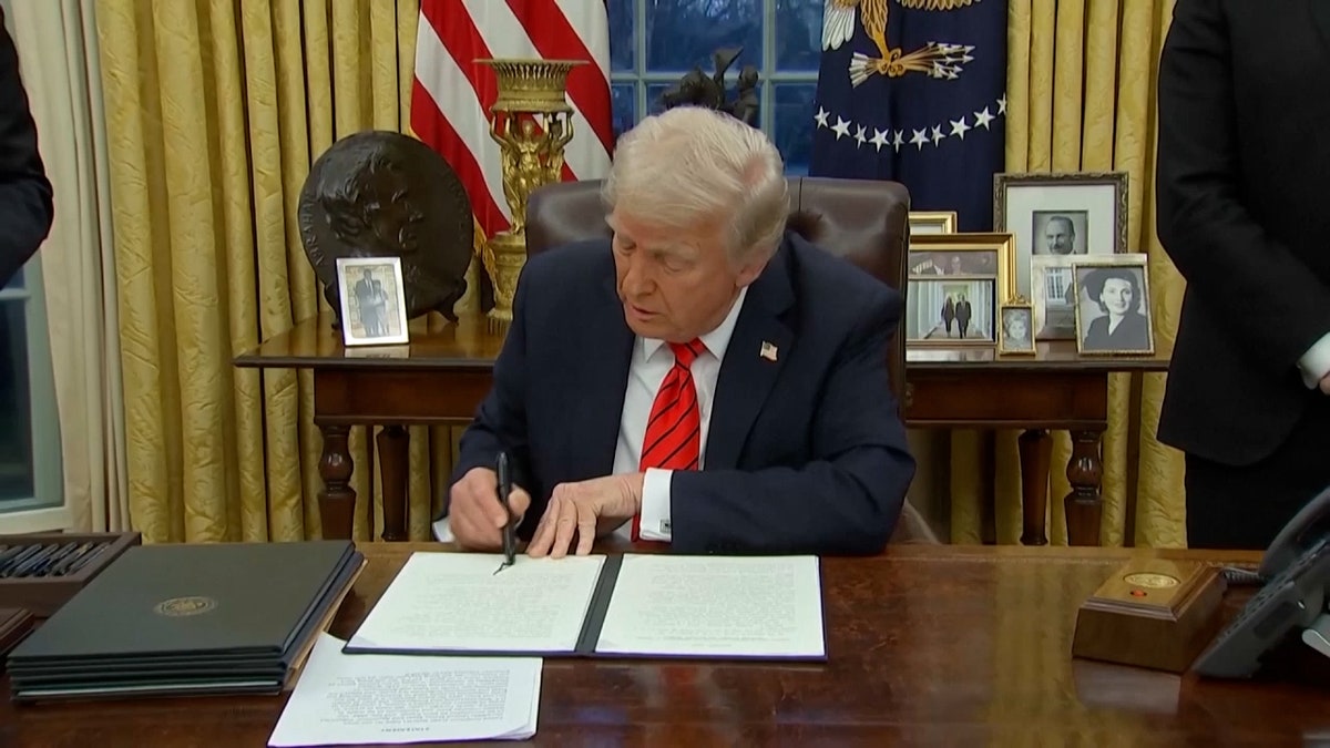 Trump at Oval Office desk signing executive order