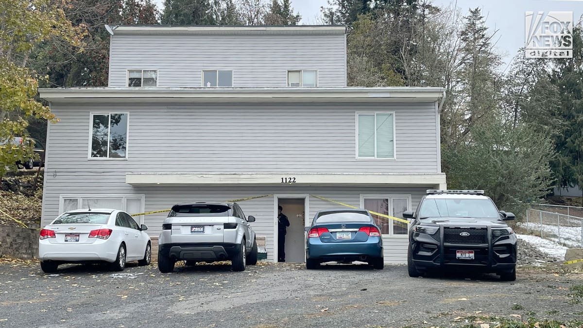 Home with police tape and four vehicles in front