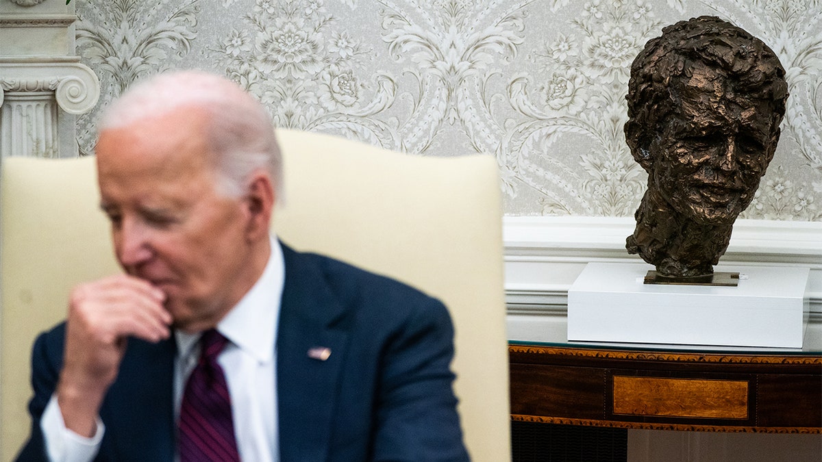 A bust of Robert F. Kennedy Jr. sits behind President Biden in the White House