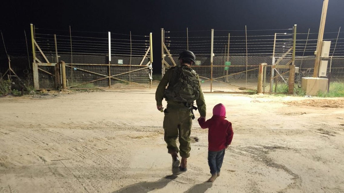 IDF soldier walks a Palestinian child back to Gaza