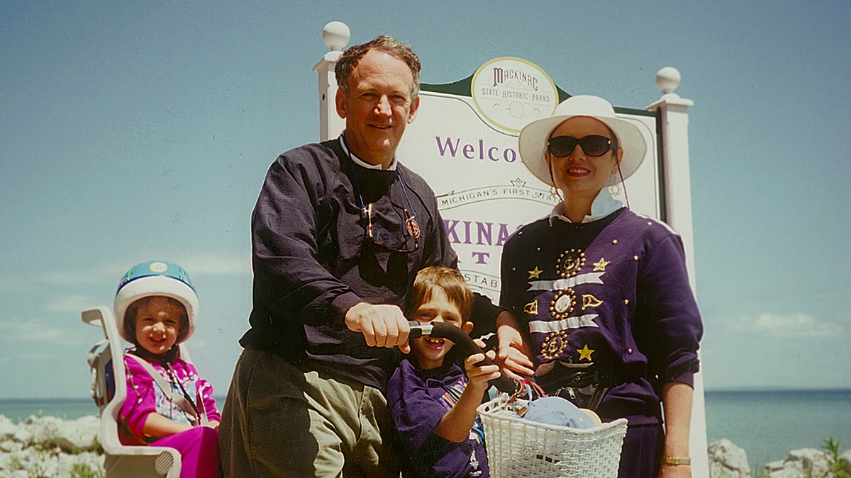 John Ramsey and his family enjoying a vacation and smiling.