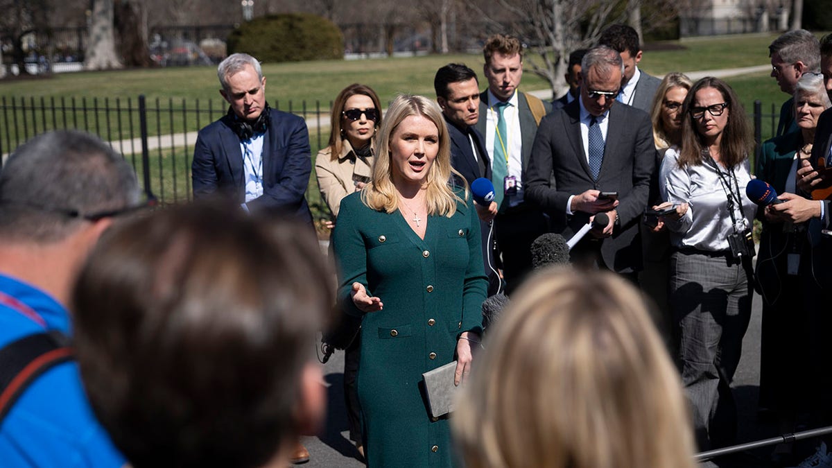 Reporters gather around Leavitt outside the White House