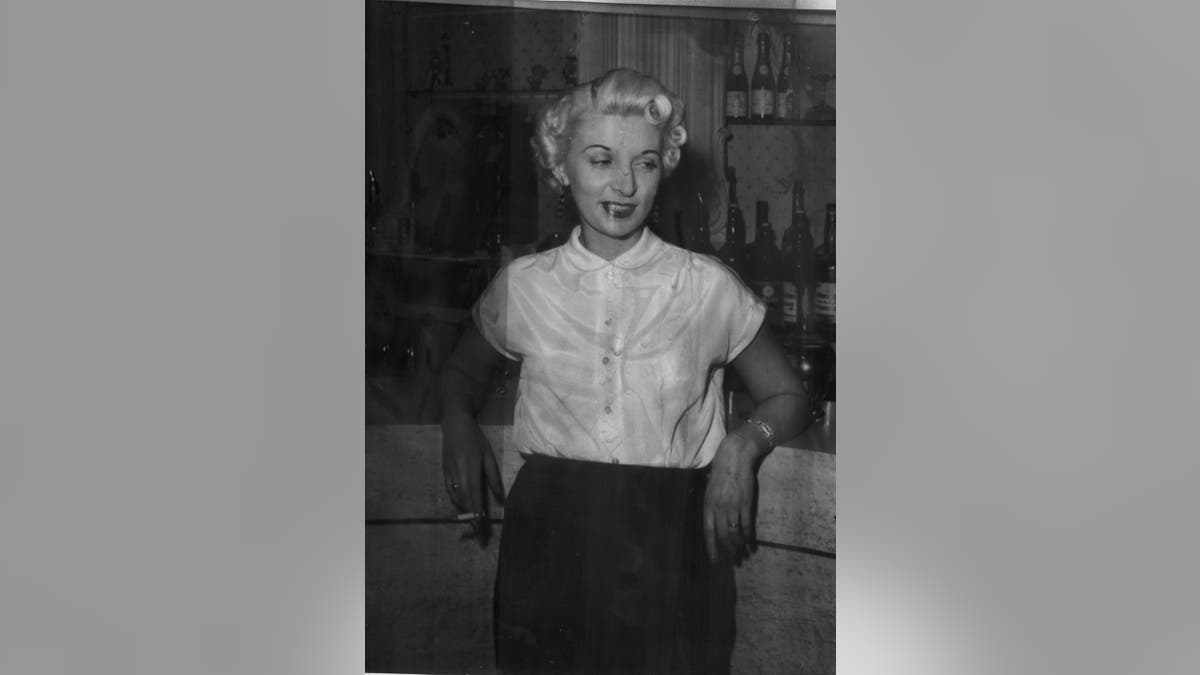 Ruth Ellis wearing a white shirt and a black pencil skirt.