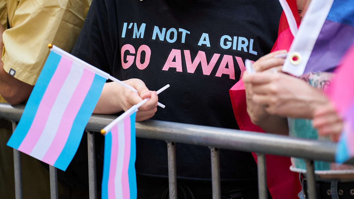 closeup shot on black trans rights t-shirt with baby blue, pink lettering