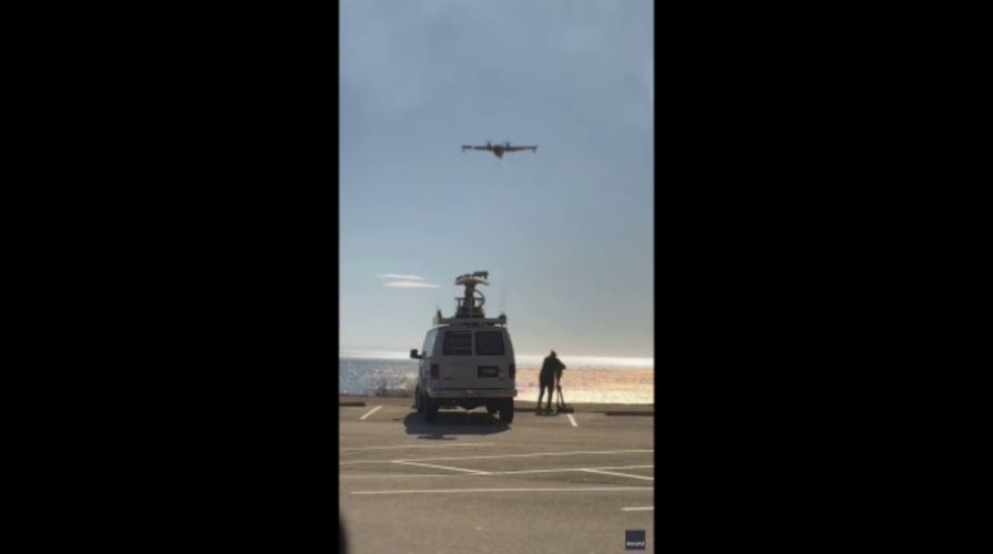 Firefighter plane scoops ocean water to battle Southern California wildfires