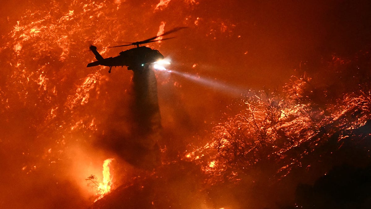 Palisades fire with helicopter in sky 