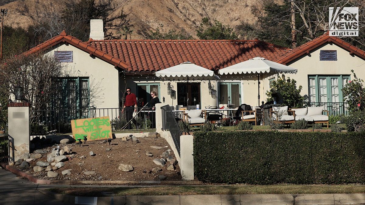 A sign in front of an Altadena home in the California fires says looters will be shot