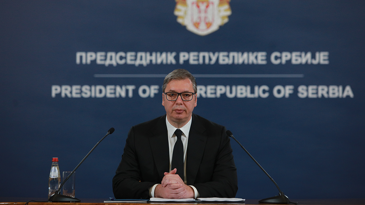 President of Serbia speaking in front of microphones to his nation