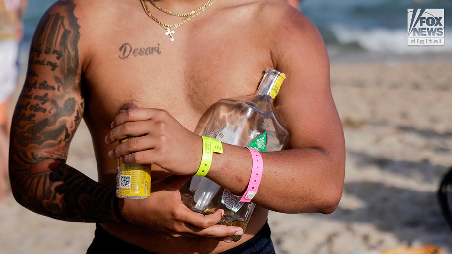 A spring breaker carries drinks on Fort Lauderdale Beach