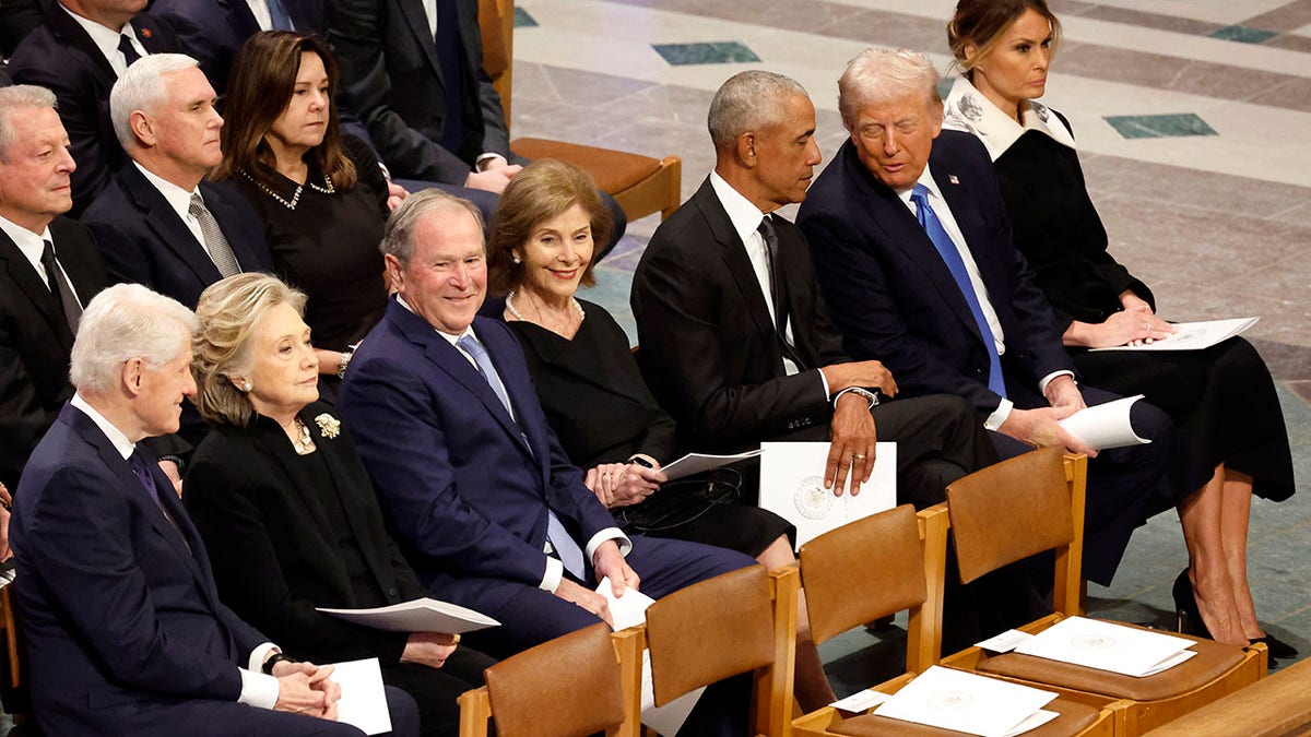 Trump chats with Obama, with Pence sat behind then, at Carter funeral