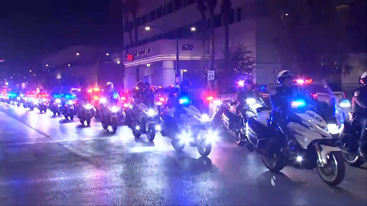 North Las Vegas Police Department (NLVPD) officers ride motorcycles in procession for a slain fellow officer.