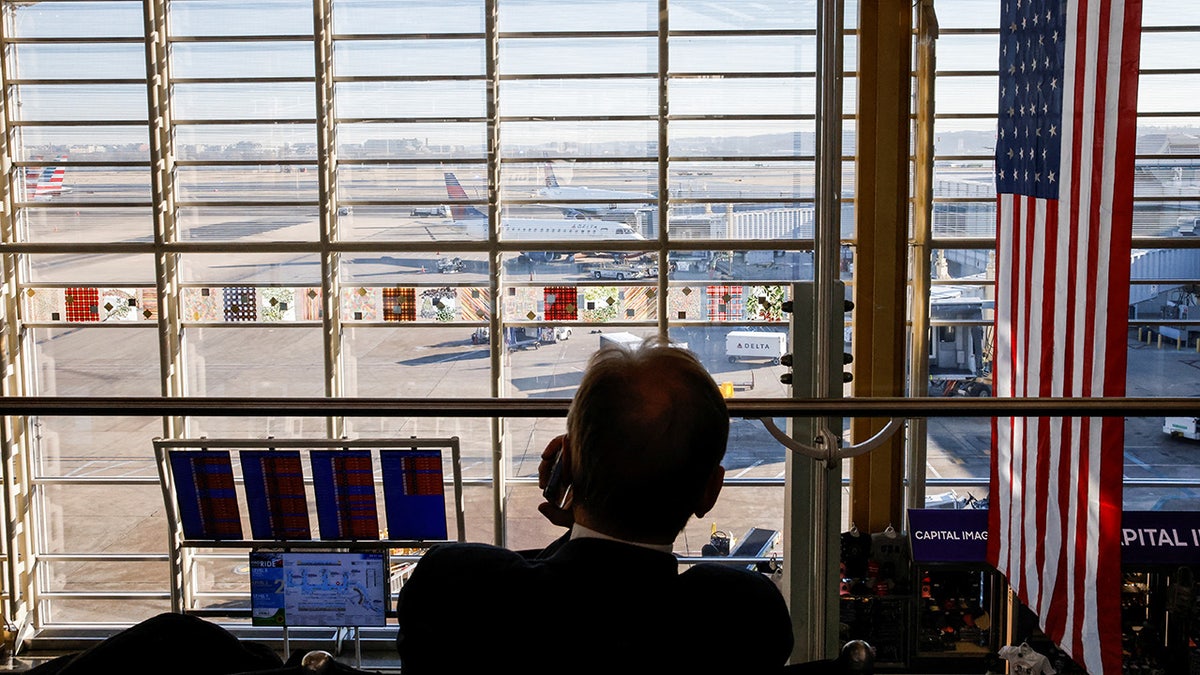 A person uses a phone at Ronald Reagan Washington National Airport