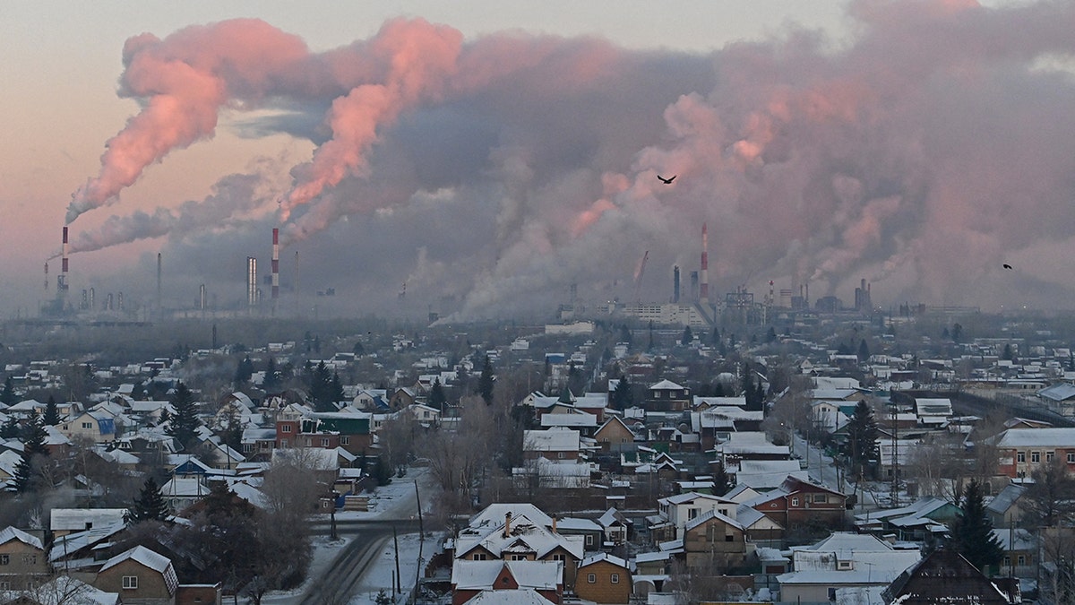 Steam rises from chimneys of the Gazprom Neft's oil refinery in Omsk