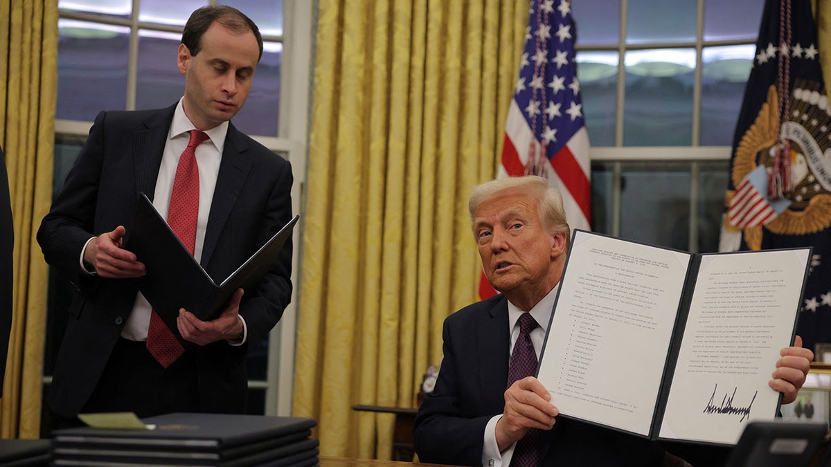 Donald Trump showing pardon document he just signed