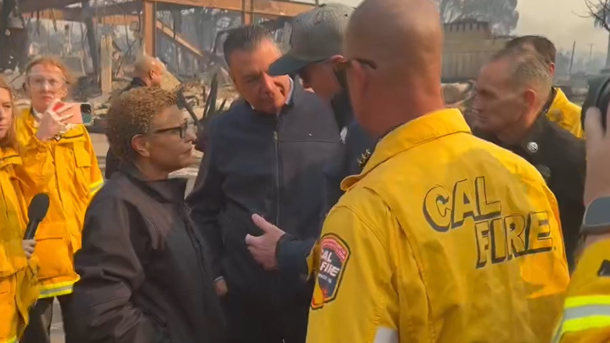 Los Angeles Mayor Karen Bass listens as Gov. Gavin Newsom speaks while touring fire damage in the city Wednesday.