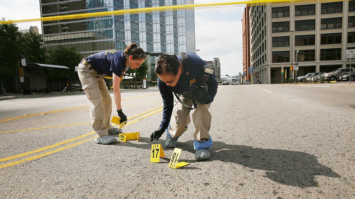 Members of an FBI evidence response team search an area