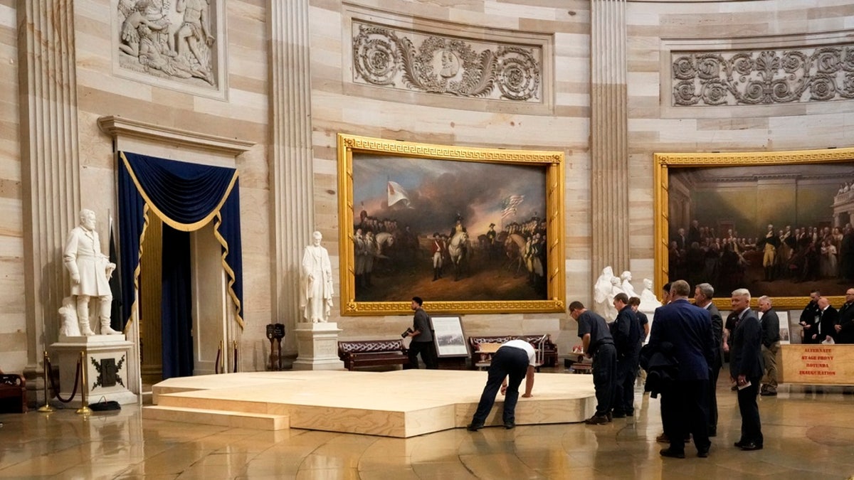 Workers build a stage in the U.S. Capitol Rotunda in Washington, D.C., Friday, for the 60th presidential inauguration, which was moved indoors because of cold temperatures expected Monday. 