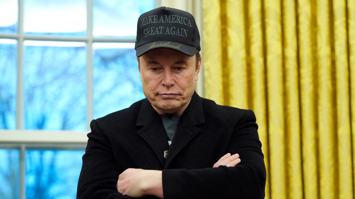 Elon Musk in black ball cap in Oval Office