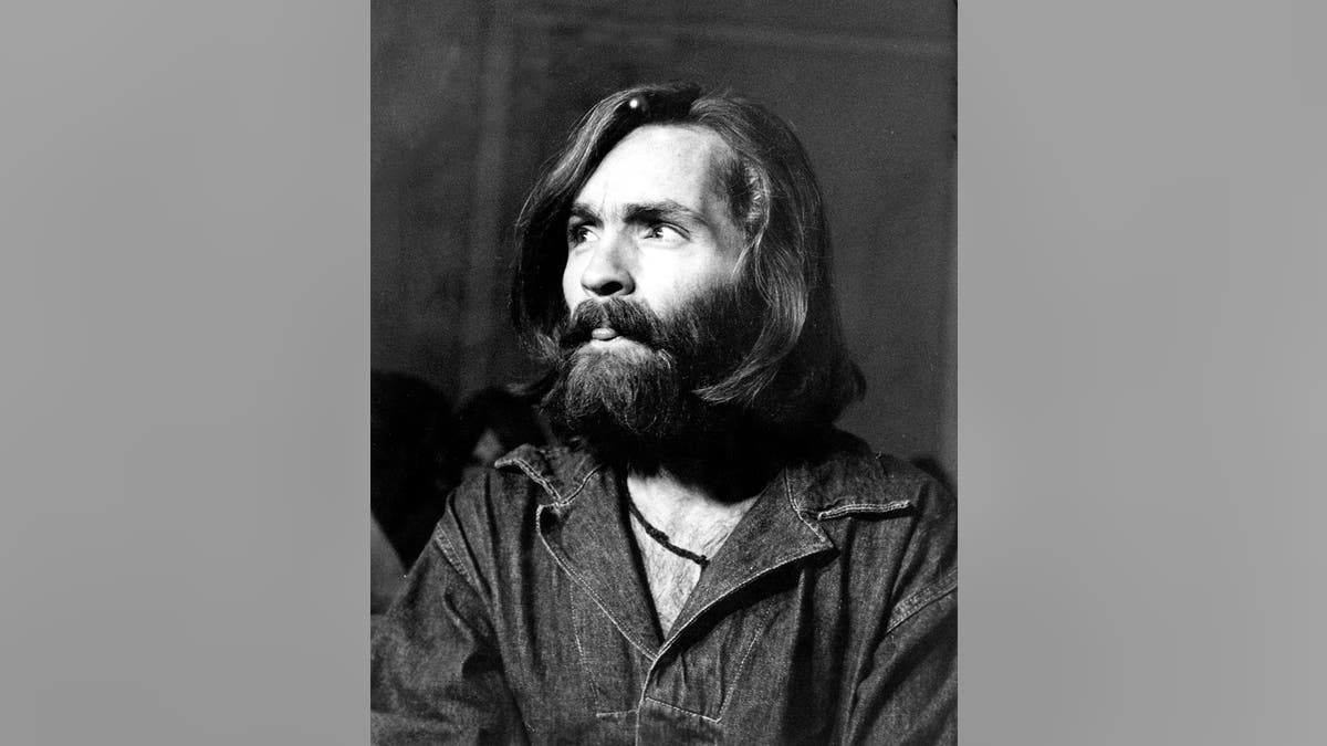 Charles Manson looking up in a denim shirt