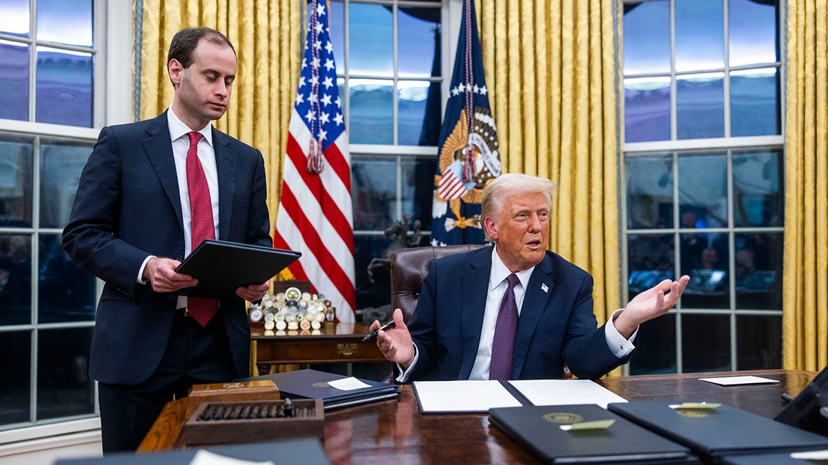 Trump gestures to press while seated in the Oval Office