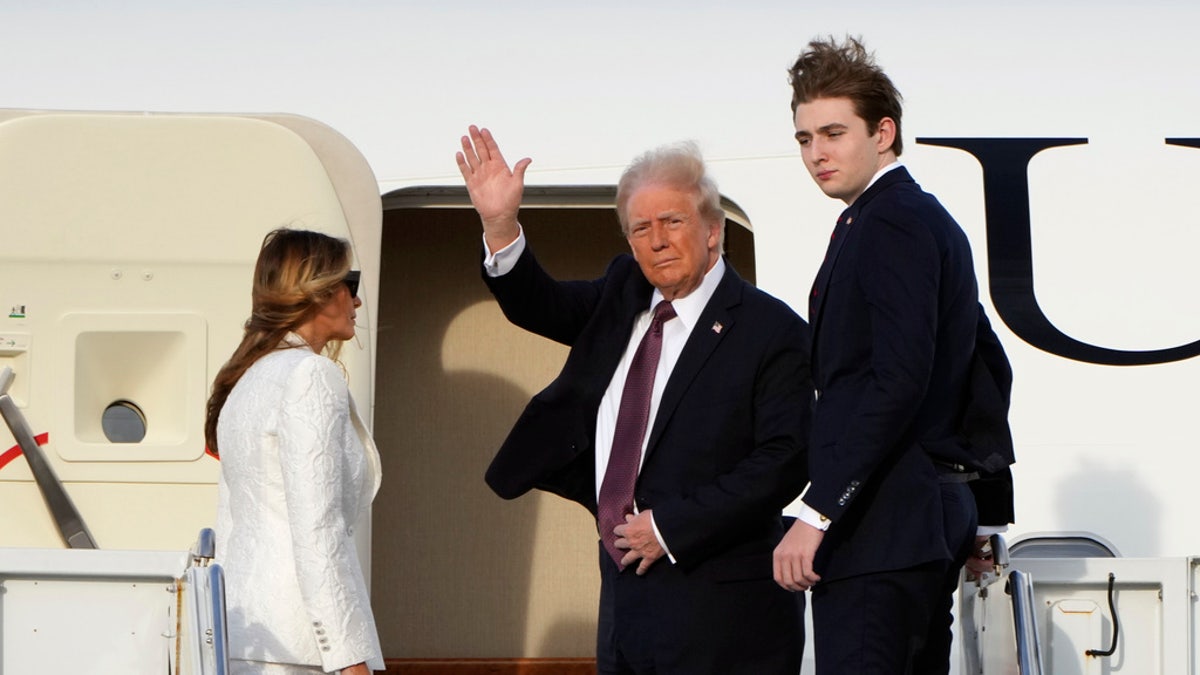 President-elect Trump, standing with Melania and Barron Trump, waves as they board an Air Force special mission airplane at Palm Beach International Airport Saturday, in West Palm Beach, Fla., en route to Washington. 