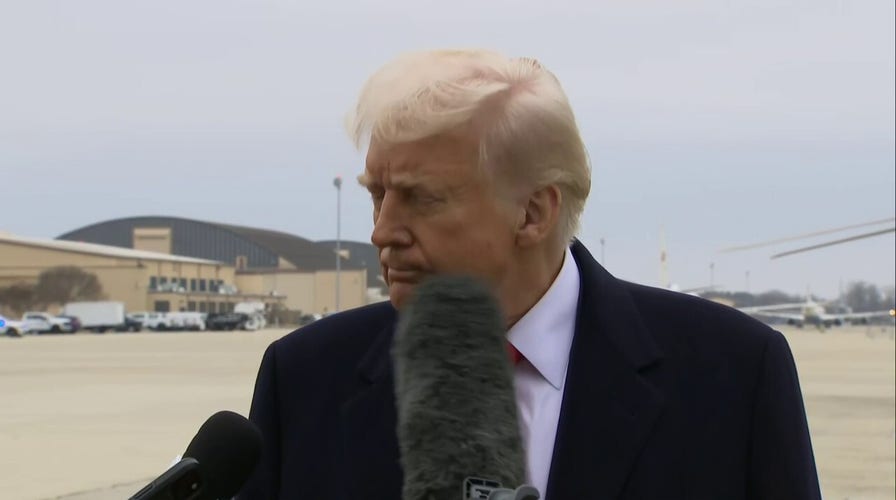 President Donald Trump is hit by a reporter's microphone while speaking with media at Joint Base Andrews