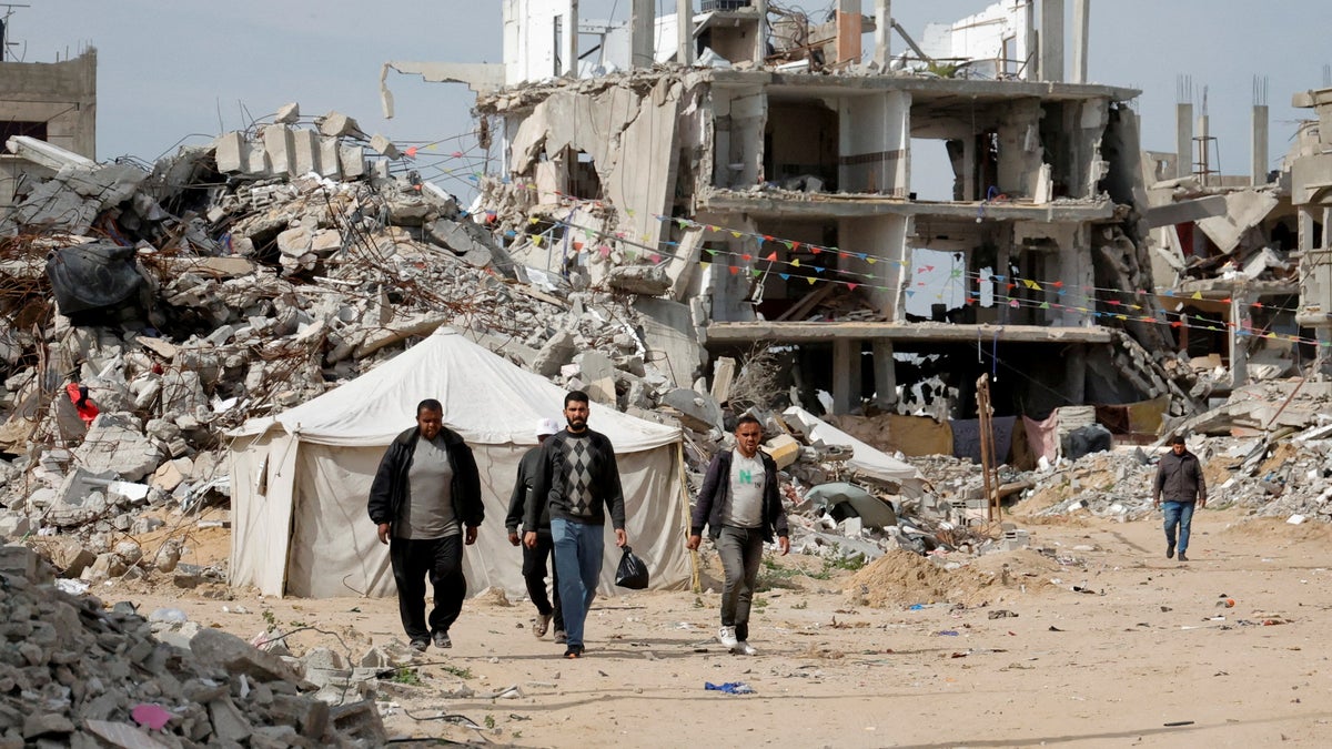 Palestinians walk in rubble of Rafah, Gaza 