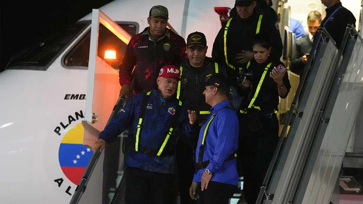 Venezuelan Interior Minister Diosdado Cabello walks off a plane that transported migrants deported from the United States