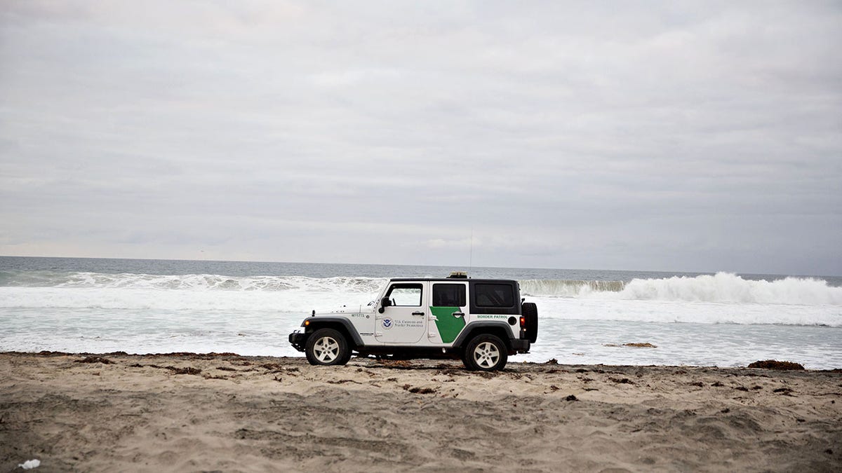 A Border Patrol vehicle on the beach