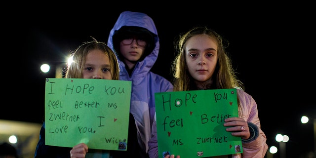 Willow Crawford, left, and her older sister Ava, right, join friend Kaylynn Vestre, center, in expressing their support for Richneck Elementary School first-grade teacher Abby Zwerner during a candlelight vigil in her honor at the School Administration Building in Newport News, Virginia, Monday, Jan. 9, 2023. Zwerner was shot and wounded by a 6-year-old student while teaching class on Friday, Jan. 6.