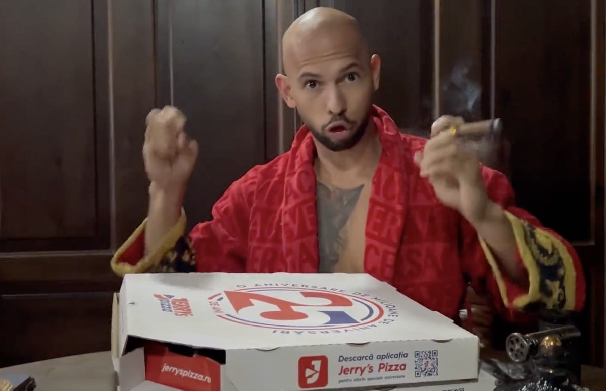 Andrew Tate in a robe, with cigar and pizza box