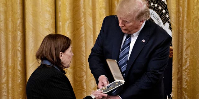 U.S. President Donald Trump presents the Presidential Citizens Medal to Susan Rescorla, wife of Richard Rescorla, during an event in the East Room of the White House in Washington, D.C., U.S., on Thursday, Nov. 7, 2019. Trump presented the medal posthumously to Richard Rescorla, who helped save the lives of nearly 2,700 people at the World Trade Center on the morning of September 11, 2001. 